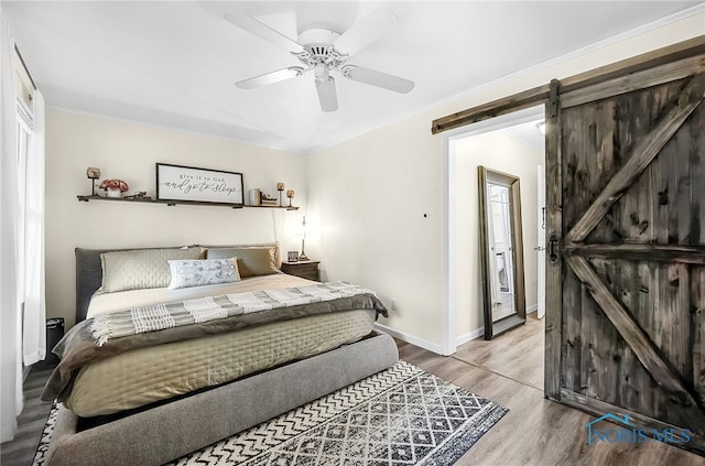 550 W 2nd St, Perrysburg, OH 43551 - bedroom featuring a barn door, wood finished floors, and ceiling fan