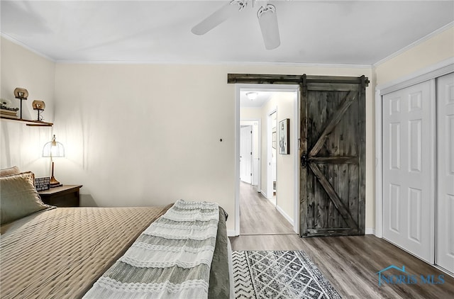 550 W 2nd St, Perrysburg, OH 43551 - bedroom featuring wood finished floors, a barn door, crown molding, a ceiling fan, and a closet