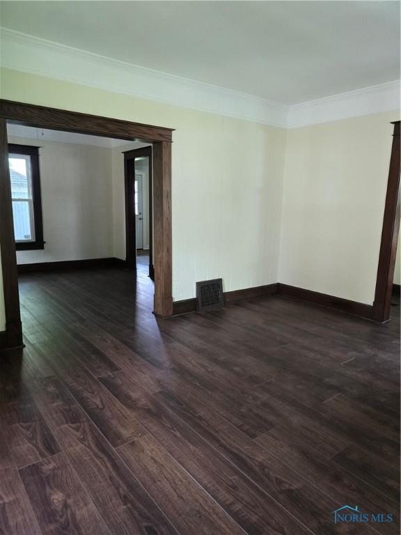 1019 Wayne Ave, Defiance, OH 43512 - spare room with crown molding and dark wood-style flooring