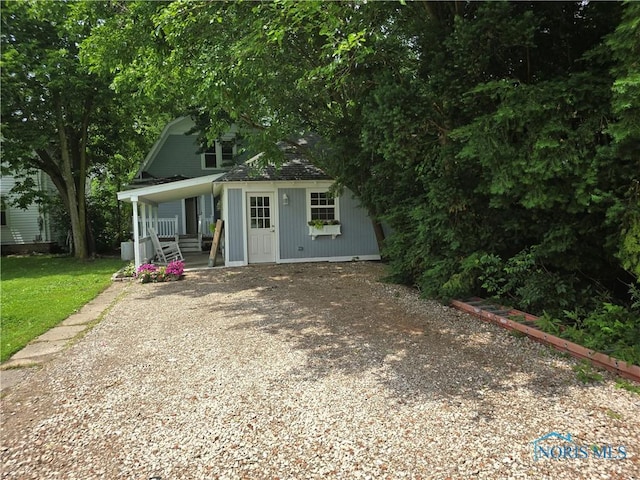 1019 Wayne Ave, Defiance, OH 43512 - view of front facade with covered porch, gravel driveway, and a shingled roof