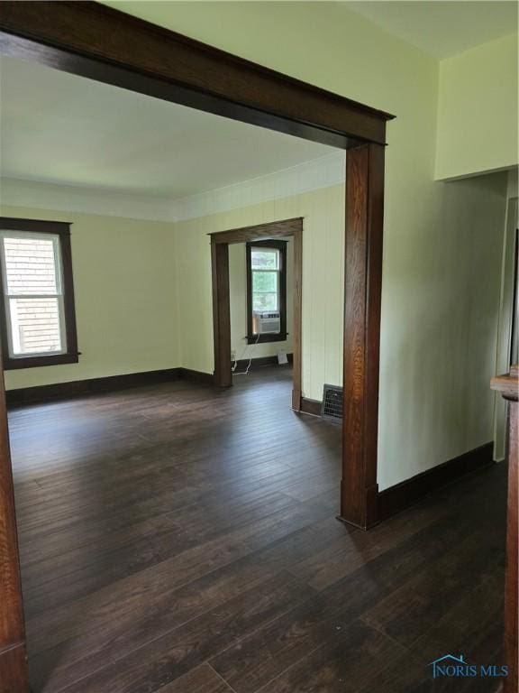 1019 Wayne Ave, Defiance, OH 43512 - empty room with dark wood finished floors, cooling unit, and ornamental molding