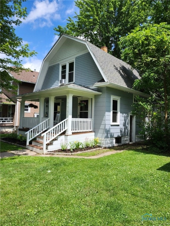 1019 Wayne Ave, Defiance, OH 43512 - colonial inspired home with covered porch, a gambrel roof, a shingled roof, a chimney, and a front lawn