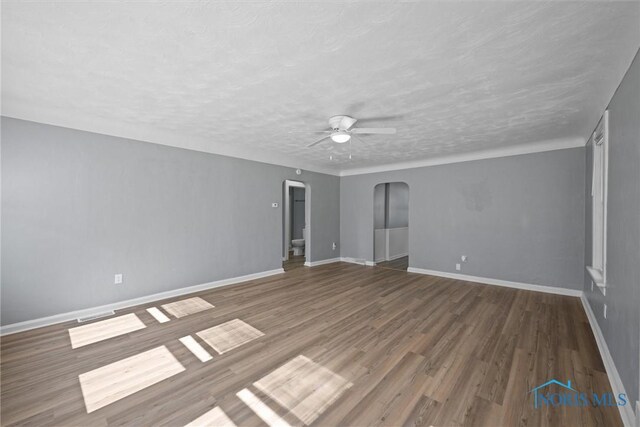 5542 N Summit St, Toledo, OH 43611 - unfurnished room with arched walkways, a ceiling fan, wood finished floors, and a textured ceiling