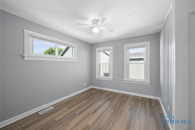5542 N Summit St, Toledo, OH 43611 - empty room featuring dark wood finished floors, a textured ceiling, and a ceiling fan