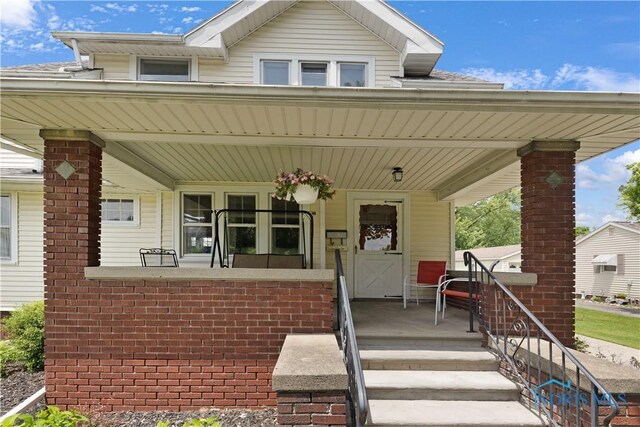 125 Cherry St, Wauseon, OH 43567 - view of front facade with covered porch and brick siding