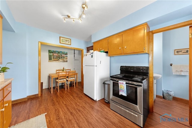 125 Cherry St, Wauseon, OH 43567 - kitchen featuring stainless steel electric range oven, freestanding refrigerator, light wood-type flooring, and light countertops