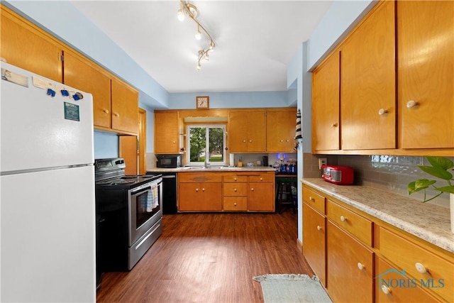 125 Cherry St, Wauseon, OH 43567 - kitchen featuring freestanding refrigerator, stainless steel electric range oven, light countertops, dark wood-style flooring, and brown cabinets