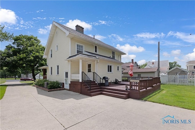 125 Cherry St, Wauseon, OH 43567 - back of property featuring a chimney, a wooden deck, and a patio