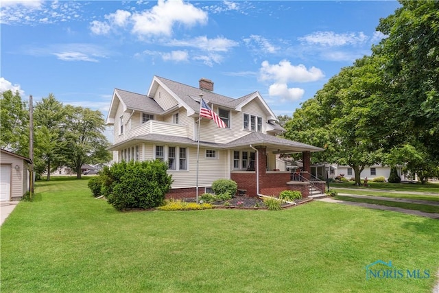 125 Cherry St, Wauseon, OH 43567 - view of front facade featuring covered porch, a chimney, a front lawn, and brick siding