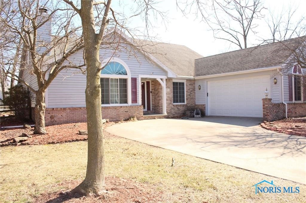 4871 Olde Meadow Ln, Sylvania, OH 43560 - single story home with brick siding, a garage, and concrete driveway