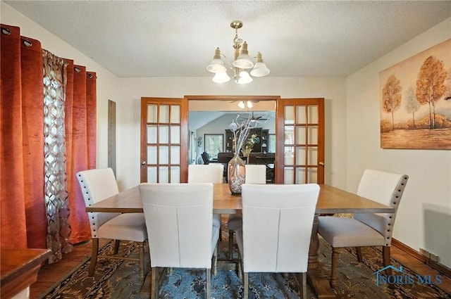 4871 Olde Meadow Ln, Sylvania, OH 43560 - dining room with french doors, a chandelier, wood finished floors, and a textured ceiling