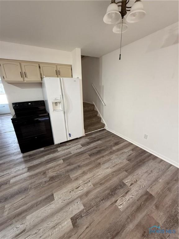 3031 Douglas Rd, Toledo, OH 43606 - kitchen featuring black electric range oven, white refrigerator with ice dispenser, and dark wood-type flooring