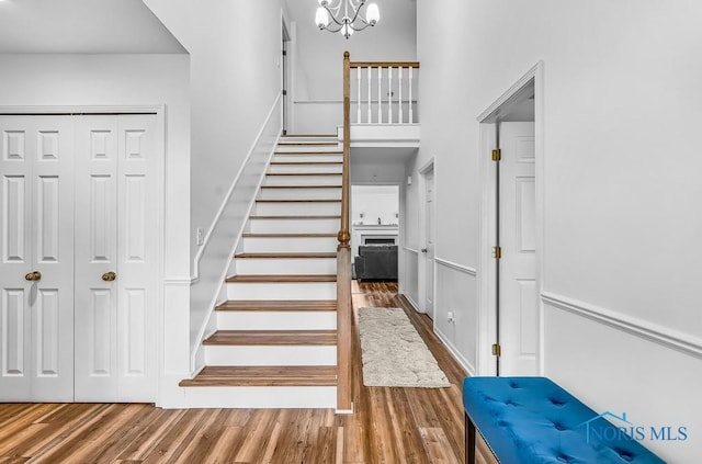 2923 Belle Glade Dr, Toledo, OH 43617 - stairs featuring wood finished floors, a chandelier, and a fireplace