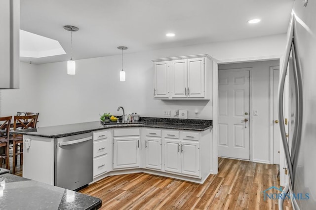2923 Belle Glade Dr, Toledo, OH 43617 - kitchen with stainless steel appliances, white cabinetry, a peninsula, light wood-type flooring, and decorative light fixtures