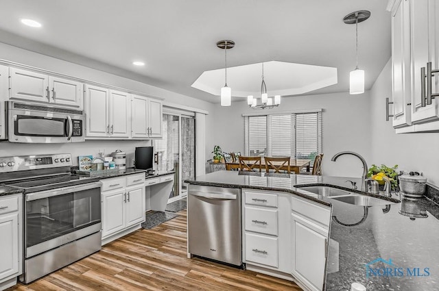 2923 Belle Glade Dr, Toledo, OH 43617 - kitchen with appliances with stainless steel finishes, a tray ceiling, white cabinetry, recessed lighting, and pendant lighting
