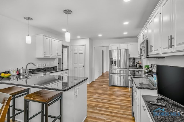 2923 Belle Glade Dr, Toledo, OH 43617 - kitchen featuring appliances with stainless steel finishes, recessed lighting, a peninsula, light wood finished floors, and white cabinetry
