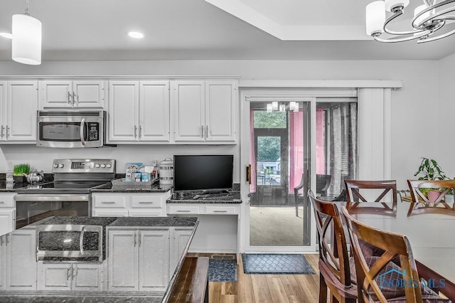 2923 Belle Glade Dr, Toledo, OH 43617 - kitchen featuring appliances with stainless steel finishes, white cabinetry, wood finished floors, a chandelier, and pendant lighting