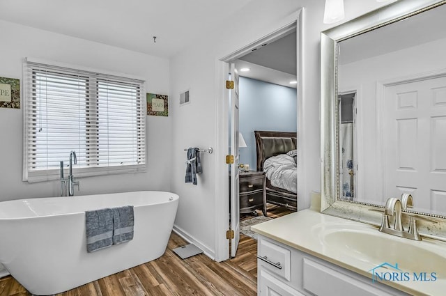 2923 Belle Glade Dr, Toledo, OH 43617 - bathroom with connected bathroom, wood finished floors, vanity, and a freestanding bath