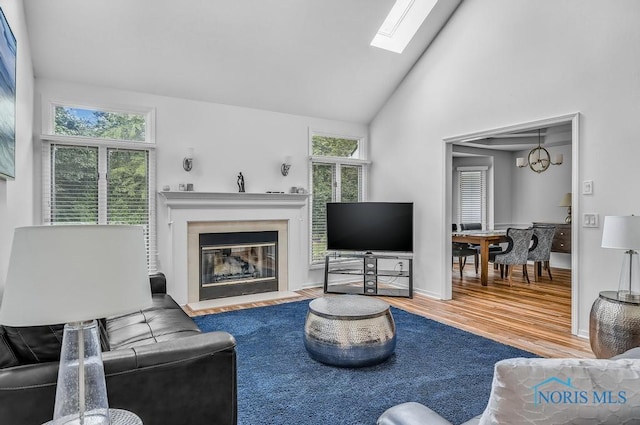 2923 Belle Glade Dr, Toledo, OH 43617 - living area featuring wood finished floors, a fireplace with flush hearth, a skylight, and high vaulted ceiling