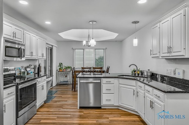2923 Belle Glade Dr, Toledo, OH 43617 - kitchen with stainless steel appliances, a peninsula, recessed lighting, white cabinets, and light wood finished floors