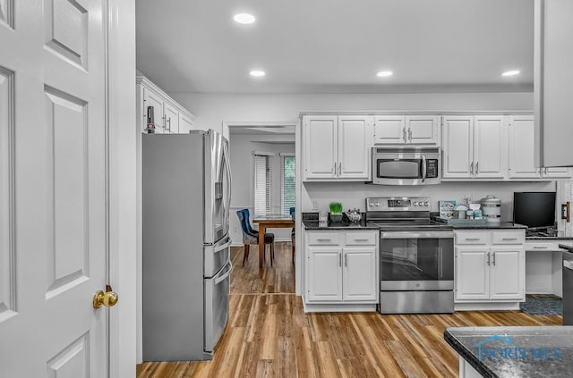 2923 Belle Glade Dr, Toledo, OH 43617 - kitchen featuring appliances with stainless steel finishes, white cabinets, light wood-style flooring, recessed lighting, and dark stone countertops