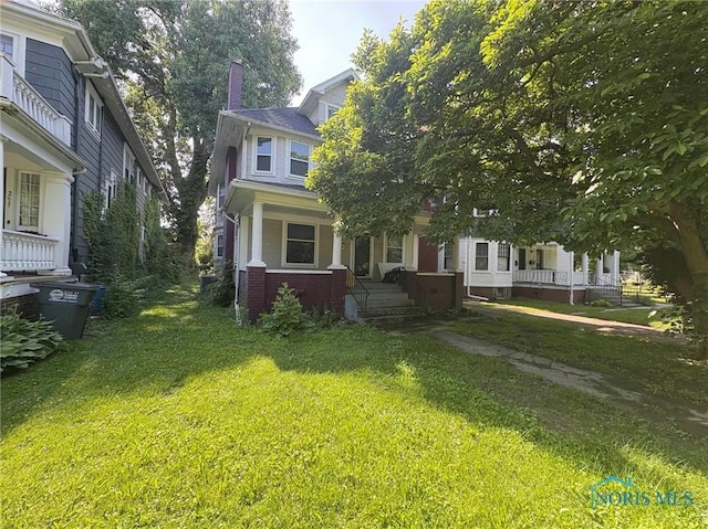 2631 Parkwood Ave, Toledo, OH 43610 - view of front facade with a porch, a chimney, a front lawn, and brick siding