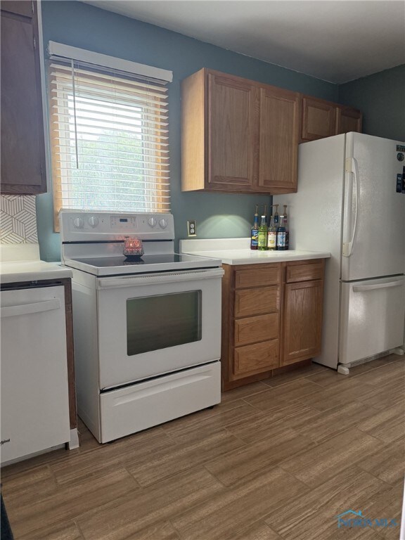 441 S Pine St, Deshler, OH 43516 - kitchen with white appliances, light countertops, wood finished floors, and brown cabinetry