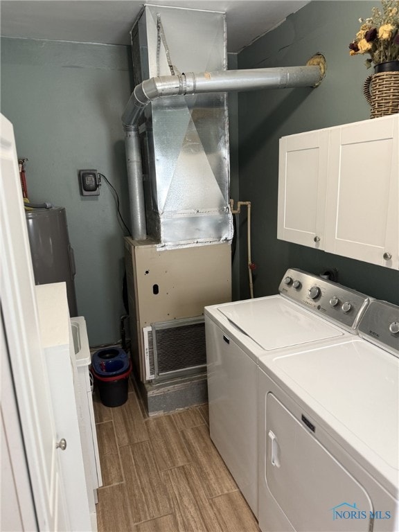 441 S Pine St, Deshler, OH 43516 - laundry room with cabinet space, washing machine and dryer, wood tiled floors, heating unit, and water heater