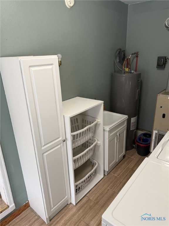 441 S Pine St, Deshler, OH 43516 - laundry area featuring water heater, cabinet space, wood finish floors, and washer / clothes dryer