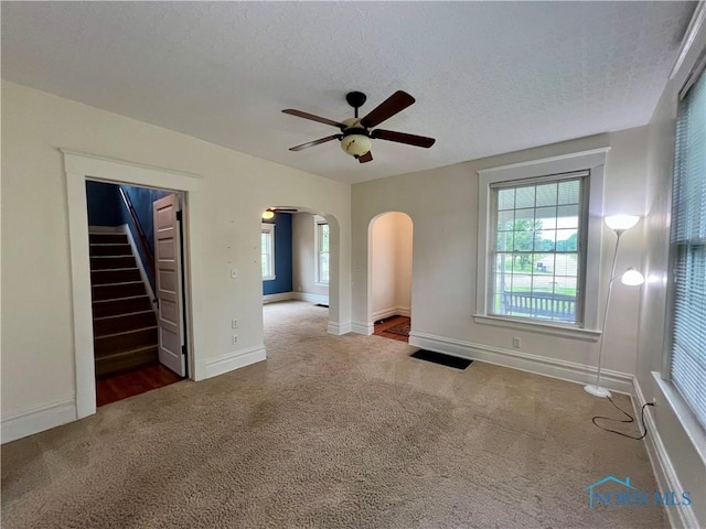 1810 E Broadway St, Toledo, OH 43605 - unfurnished room with carpet, ceiling fan, arched walkways, a textured ceiling, and stairway