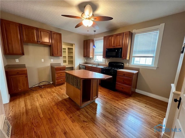 1810 E Broadway St, Toledo, OH 43605 - kitchen featuring black appliances, ceiling fan, light wood finished floors, and brown cabinetry