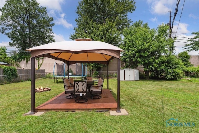 3530 Devon Hill Rd, Toledo, OH 43606 - fenced backyard featuring a trampoline, a storage shed, a gazebo, a deck, and an outdoor fire pit