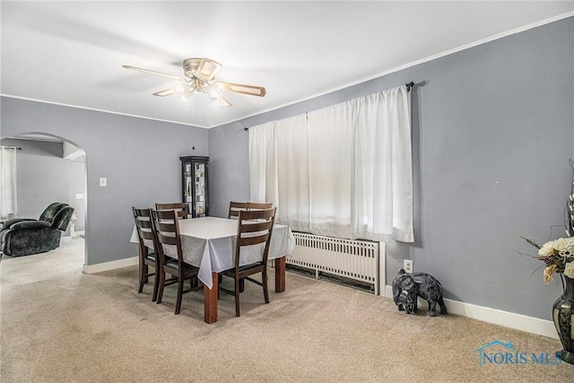 130 S 1st St, Hamler, OH 43524 - carpeted dining area with arched walkways, radiator heating unit, a ceiling fan, and ornamental molding