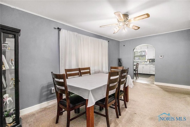 130 S 1st St, Hamler, OH 43524 - dining space with arched walkways, ceiling fan, light carpet, and crown molding