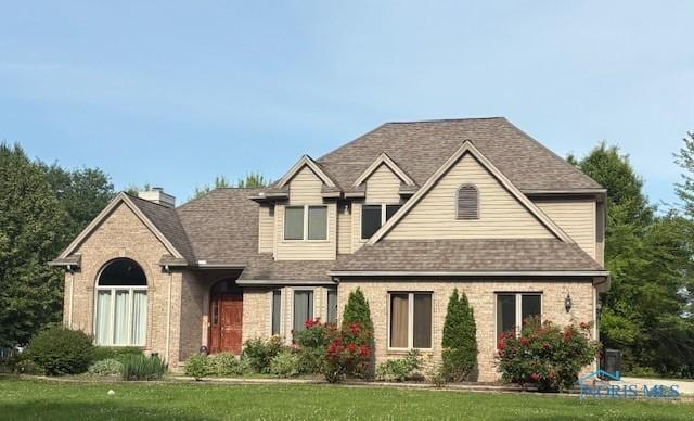 14285 Cuckle Creek Rd, Bowling Green, OH 43402 - view of front of house with brick siding, a front yard, a shingled roof, and a chimney