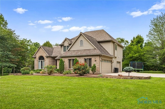 14285 Cuckle Creek Rd, Bowling Green, OH 43402 - traditional-style house featuring a trampoline, brick siding, a front lawn, concrete driveway, and a shingled roof
