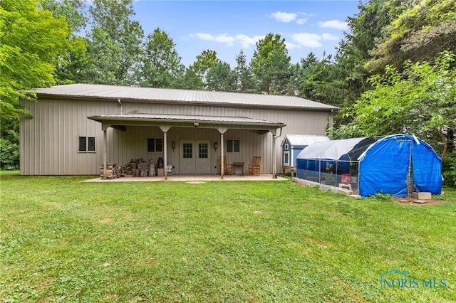14285 Cuckle Creek Rd, Bowling Green, OH 43402 - back of property with a lawn, a patio, an exterior structure, and a metal roof