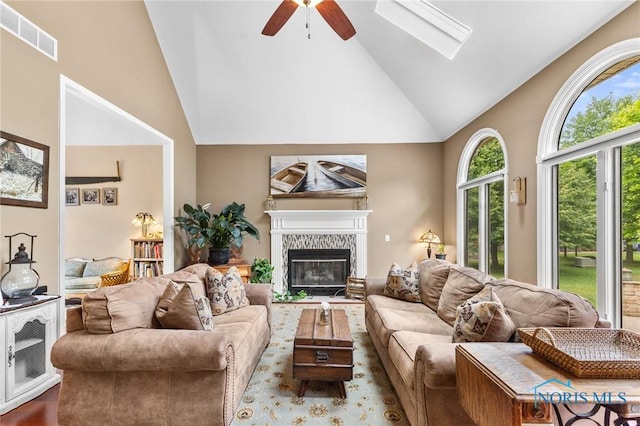 14285 Cuckle Creek Rd, Bowling Green, OH 43402 - living area with high vaulted ceiling, a ceiling fan, a glass covered fireplace, wood finished floors, and a skylight