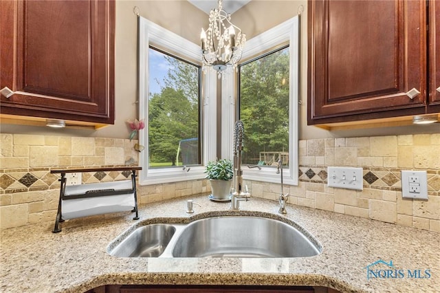 14285 Cuckle Creek Rd, Bowling Green, OH 43402 - kitchen with light stone countertops, a chandelier, and backsplash