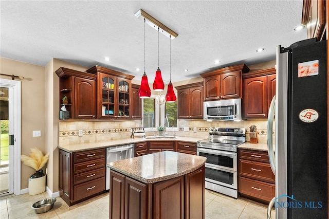 14285 Cuckle Creek Rd, Bowling Green, OH 43402 - kitchen featuring stainless steel appliances, healthy amount of natural light, decorative light fixtures, glass insert cabinets, and a textured ceiling