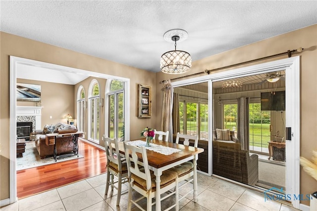 14285 Cuckle Creek Rd, Bowling Green, OH 43402 - dining space featuring light tile patterned floors, a glass covered fireplace, and a textured ceiling