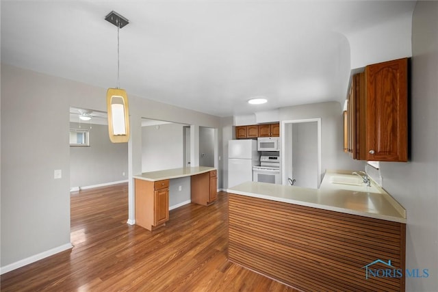 3431 146th St, Toledo, OH 43611 - kitchen with white appliances, wood finished floors, a peninsula, light countertops, and brown cabinets