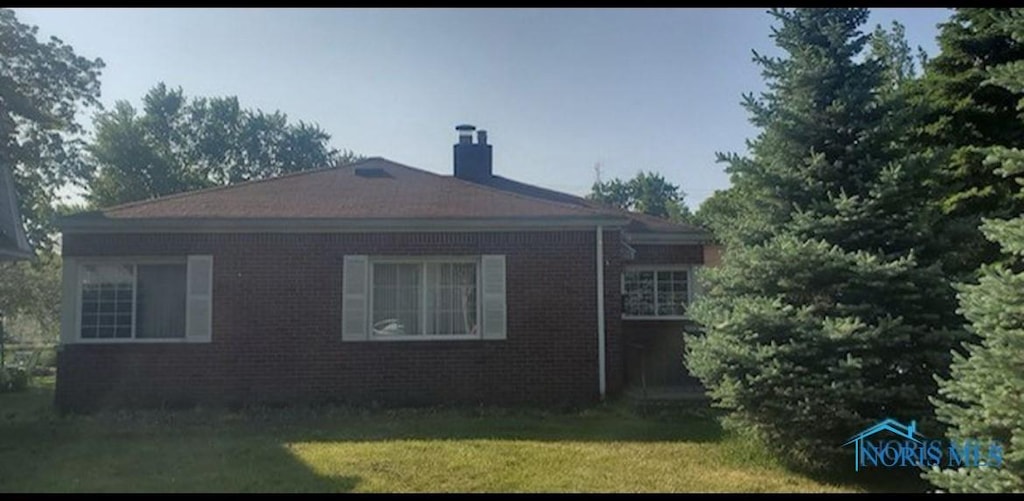 1732 Gilbert Rd, Toledo, OH 43614 - view of home's exterior with a yard, brick siding, and a chimney