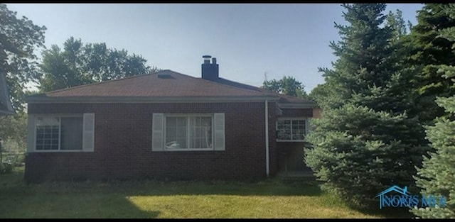 1732 Gilbert Rd, Toledo, OH 43614 - view of home's exterior with a yard, brick siding, and a chimney