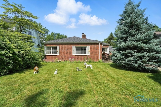 1732 Gilbert Rd, Toledo, OH 43614 - rear view of property featuring a chimney, a yard, and brick siding