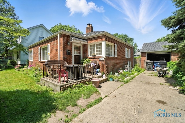 1732 Gilbert Rd, Toledo, OH 43614 - rear view of house featuring brick siding, a chimney, a garage, concrete driveway, and a yard