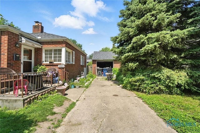 1732 Gilbert Rd, Toledo, OH 43614 - view of home's exterior featuring brick siding, a chimney, and concrete driveway
