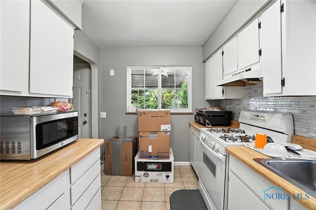1732 Gilbert Rd, Toledo, OH 43614 - kitchen featuring stainless steel microwave, under cabinet range hood, white range with gas stovetop, light tile patterned floors, and white cabinetry