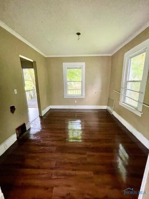 2024 Elliott Ave, Toledo, OH 43606 - spare room featuring plenty of natural light, ornamental molding, wood finished floors, and a textured ceiling