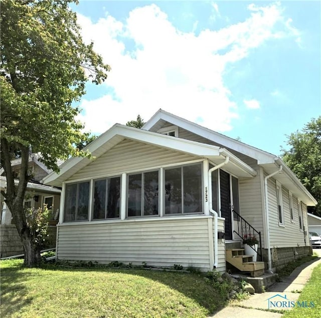1723 Balkan Pl, Toledo, OH 43613 - view of property exterior featuring a sunroom, a yard, and entry steps